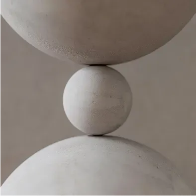 A concrete sphere, balanced between two other larger spheres